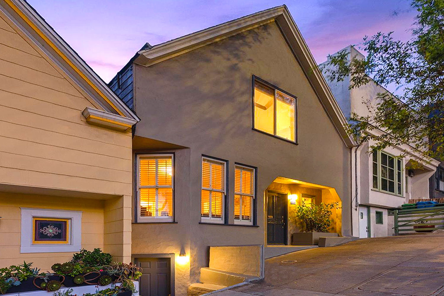 A-frame style house perched on Bernal Hill in Bernal Heights. Spectacular views of Downtown San Francisco. Exterior painted beige with navy blue trim.