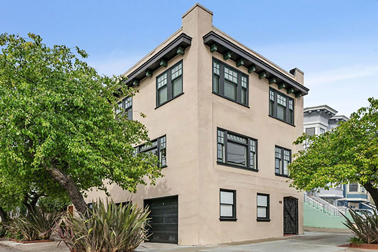 Renovated 3-story condominium building with 2 units and private garages. Originally built in 1915. Exterior painted beige with black trim. Fully detached, located on a corner lot.