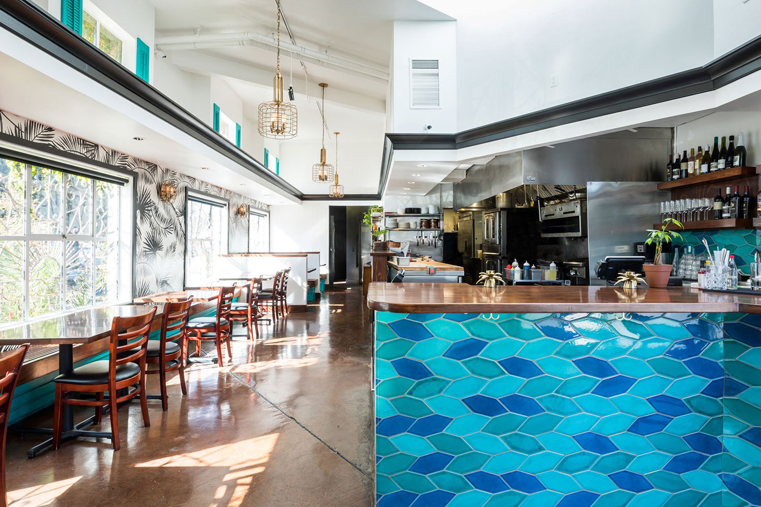 Restaurant interior. Seating areas with open style kitchen and bar. Designer blue tile counter. High ceilings, oversized windows.